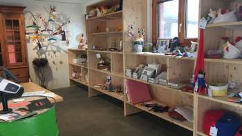 Interieur van de Birkahoflädile met houten schappen vol regionale producten, decoratief ontworpen met kleurrijke elementen - boerderijwinkel in Liechtenstein.
