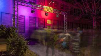 Entreegebied van het Kleintheater Schlösslekeller bij nacht met gekleurde verlichting en publiek