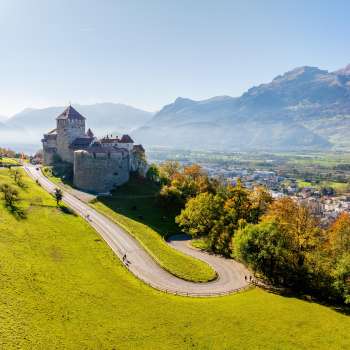 Kasteel Vaduz op een heuvel met uitzicht op de Rijnvallei en de omliggende bergen.
