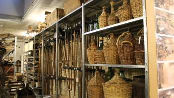Planken met traditionele gereedschappen, demijohns en alledaagse voorwerpen
