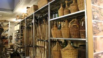 Planken met traditionele gereedschappen, demijohns en alledaagse voorwerpen