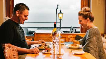 Paar genietend van een gezellig diner bij kaarslicht met uitzicht op de buitenruimte