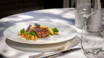 Exquis hoofdgerecht met sappig vlees, verse groenten en decoratieve bloemen