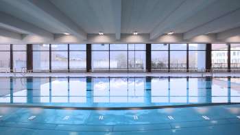 Zicht op het blauwe zwembad in het overdekte zwembad van Triesen