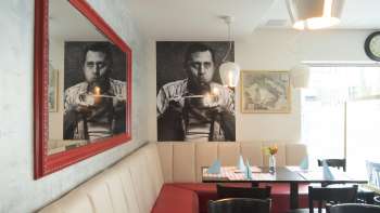 Gezellige zithoek in restaurant Made in Italy een stijlvolle wanddecoratie en een rode spiegel