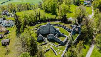 Luchtfoto van de burchtruïne Schellenberg in Liechtenstein, omgeven door groen landschap - een populaire excursiebestemming met historische flair