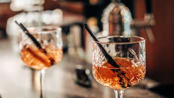 Twee aperitiefglazen met sinaasappelschijfjes op de bar