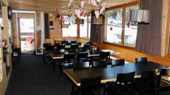 Gezellige eetzaal met houten muren, rustieke sfeer en liefdevolle decoratie in restaurant Schneeflucht