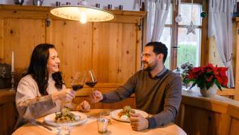 Een koppel dineert in de gezellige houten salon van Gasthof Au Een koppel dineert in de gezellige houten salon van Gasthof Au