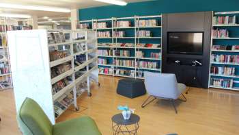 Gezellige leeshoek in de Nationale Bibliotheek van Liechtenstein met fauteuils en mediawand tussen hoge boekenplanken