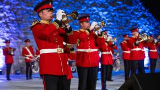 Brassbandensemble in opvallende rode uniformen op de Prinselijke Taptoe 2022 in Liechtenstein - feestelijk optreden met traditionele klanken.