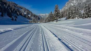 Vers geprepareerde langlaufloipe in Steg met panoramisch uitzicht op het besneeuwde Alpenlandschap