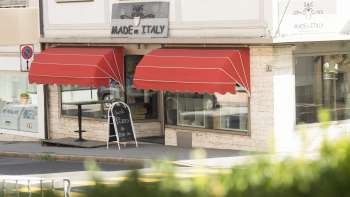 Buitenaanzicht van het Made in Italy restaurant met opvallende rode luifel in Vaduz.