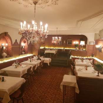 Lange eetzaal met elegant gedekte tafels en sfeervolle verlichting