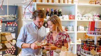 Een stel ontdekt regionale specialiteiten in de Hoi-Laden in Vaduz - ervaar authentieke producten uit Liechtenstein van dichtbij.