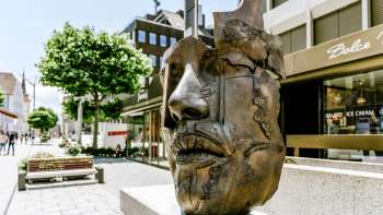 Moderne bronzen sculptuur van een gezicht in het centrum van Vaduz