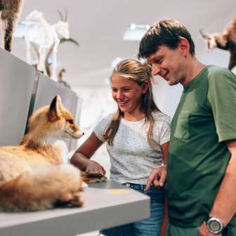 Vader en dochter bekijken een opgezet dier in het Liechtensteinisches LandesMuseum