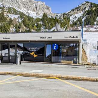 Ingang tot het Malbun Centrum met toeristische informatie en restaurant voor een besneeuwd berglandschap in Malbun, Liechtenstein