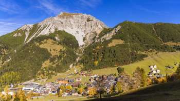 Uitzicht op het bergdorp Malbun in Liechtenstein met het omringende berglandschap onder een heldere hemel.