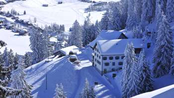 Traditionele bergherberg Sücka midden in een groen landschap en omgeven door bossen