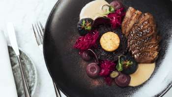 Stijlvol bereid eten op een zwart bord in hoofdstuk twee